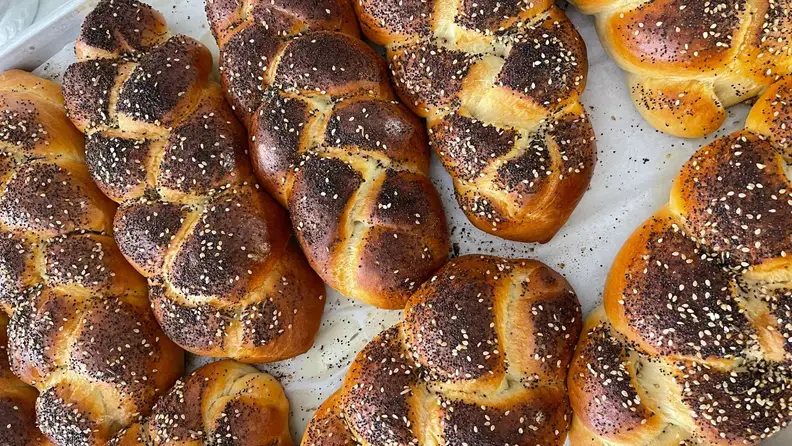 Loaves of challah covered in everything seed seasoning.