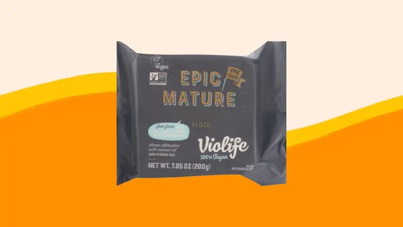 A product photo of Violife Cheddar cheese on an orange and beige background.