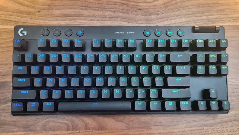 The Logitech G Pro X TKL keyboard on a wood table.