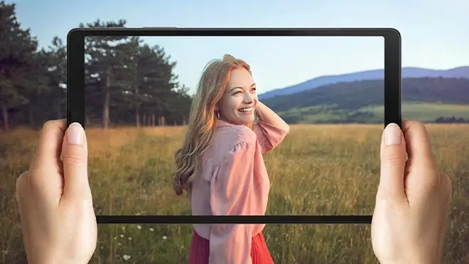 Woman smiling in field on tablet device