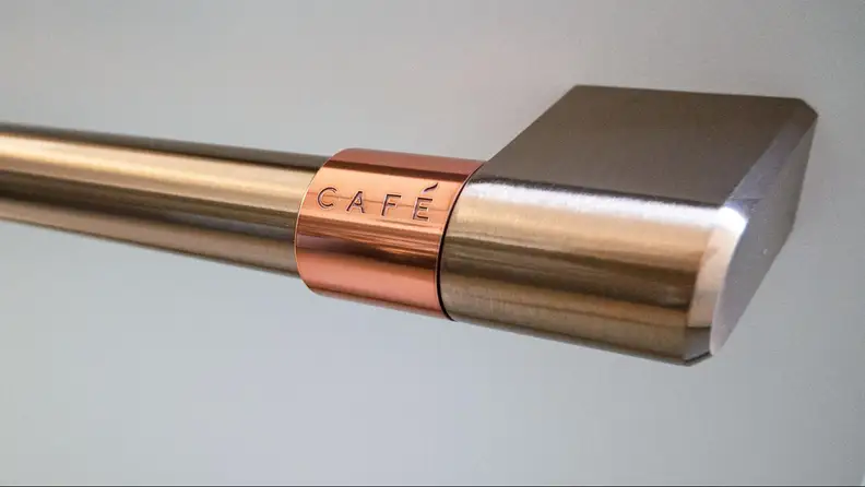 A close-up of the dishwasher's brushed copper handle, with engraved 