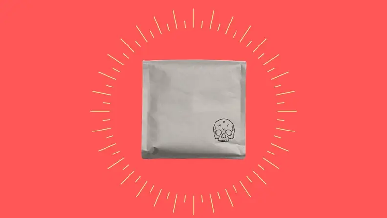 A bag of decaf coffee against a bright pink background.