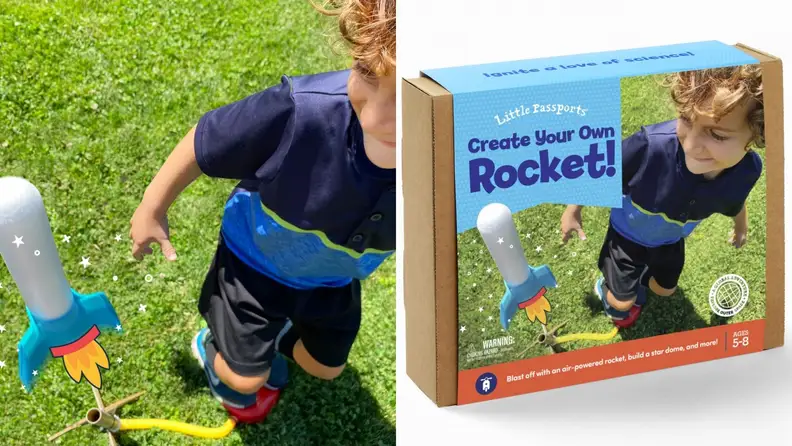 A child uses a stomp rocket and a box of the kit to make it.
