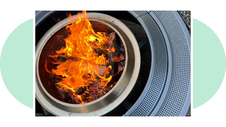 A flame burns bright in the center of the Solo Stove Surround, in a photo that highlights the ample tabletop space.