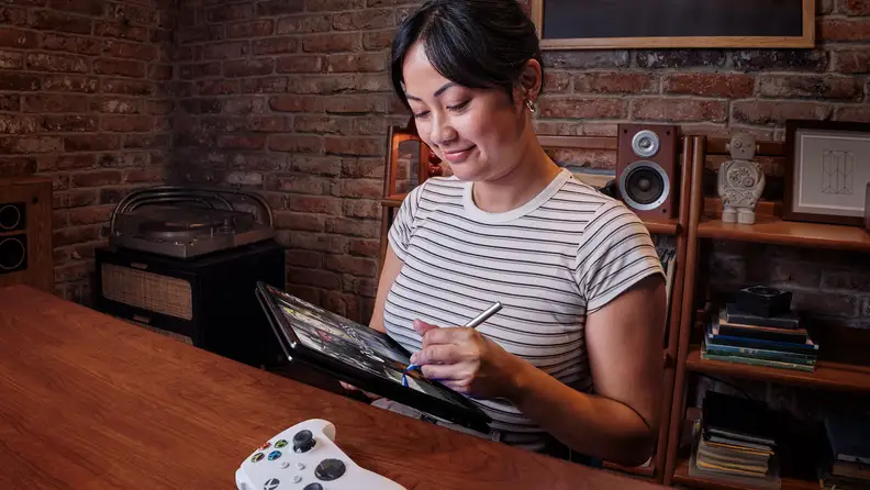 Woman using the HP Flip as a drawing tablet in a cozy brick office space