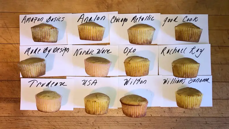 Twelve muffins lined up in three rows, each one baked in a different pan to show how we tested