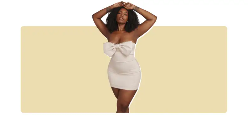 A white mini dress with a crystal-embellished bow along the bodice.