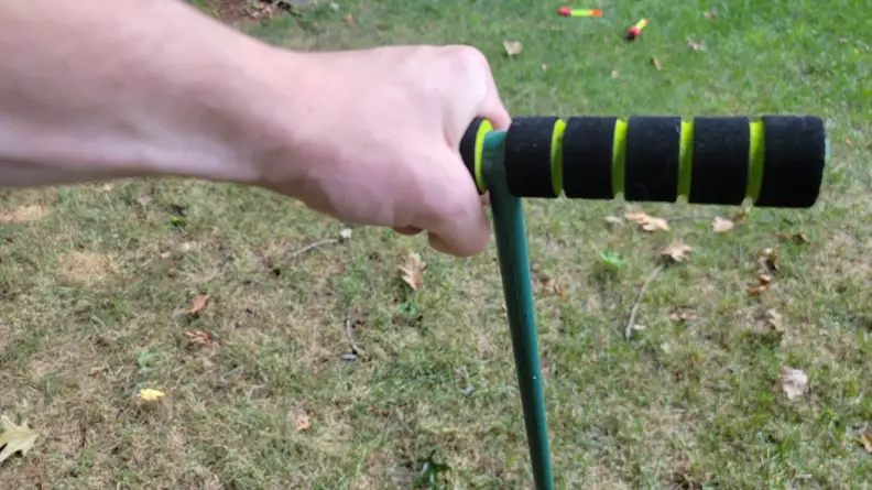 A hand grasping a padded handle of an aerator