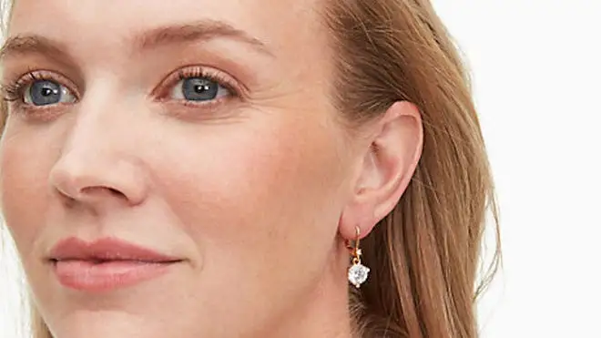 Woman smiling while wearing Kate Spade jewelry