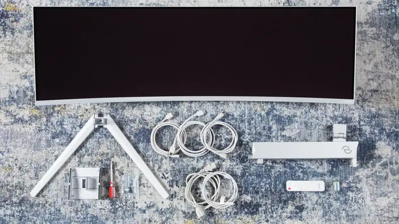 The Philips Evnia 49M2C8900 and all of its parts separated on a table.