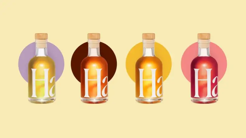 Four bottles of Haus aperitifs against a pale yellow background.