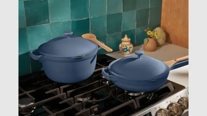 A blue Always Pan and Perfect Pot sitting beside each other on a gas range.