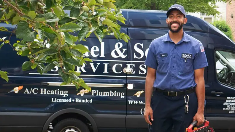 Smiling technician standing in front of a company service van
