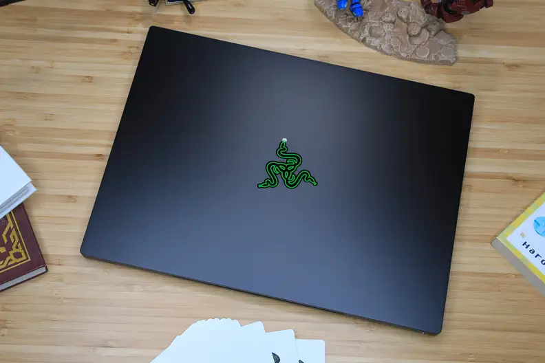 A closed, black laptop with a green snake-like logo on the lid viewed from the top-down.