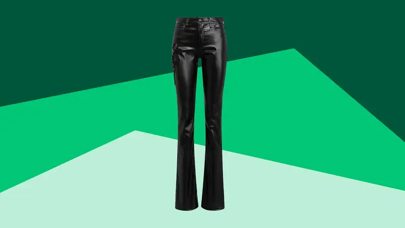 A pair of black leather trousers against a green background.