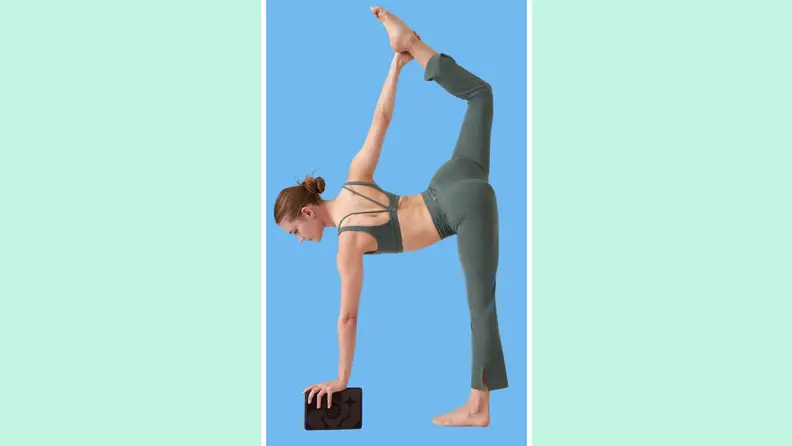 A person performing a yoga pose while holding onto a yoga block.