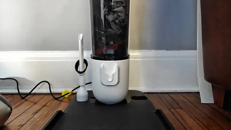 The bottom half of a vacuum base, filled with large debris