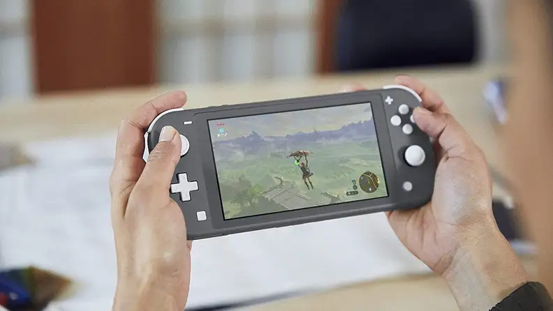 Close up of a person playing a Nintendo Switch Lite