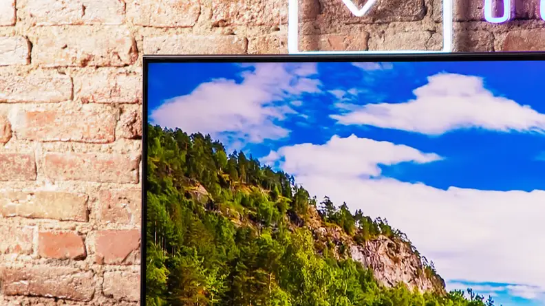 The upper left corner of the Hisense U6K Mini-LED TV, featuring clouds on the TV screen and a brick background.