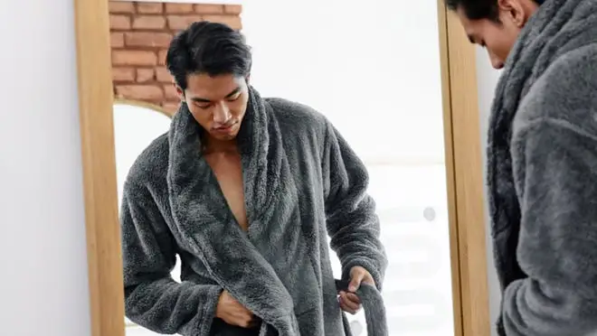 Person looking at robe in mirror.