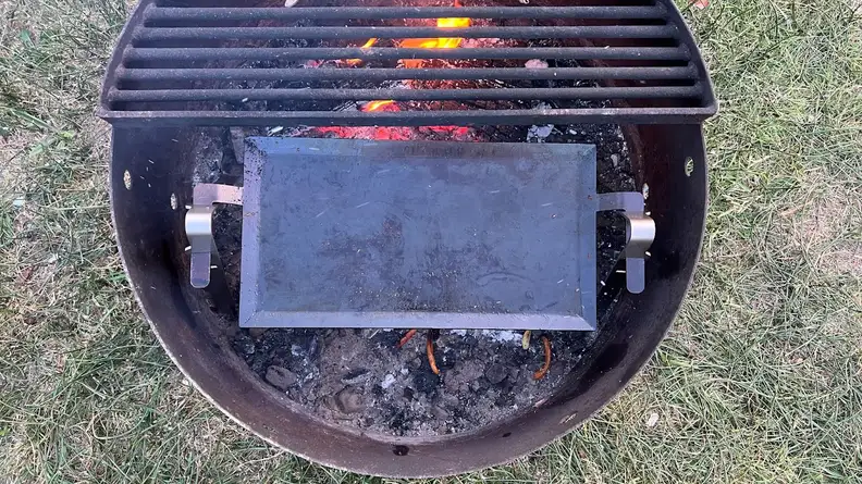 Made In Carbon Steel Griddle inside of fire pit with open flame.