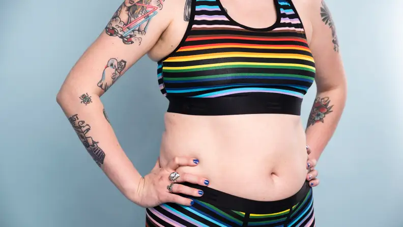 Close-up of stomach of person in TomboyX bra and TomboyX trunks.
