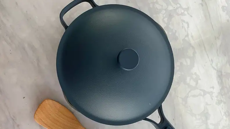 Always Pan 2.0 in Blue Salt color with lid on next to wooden spoon.