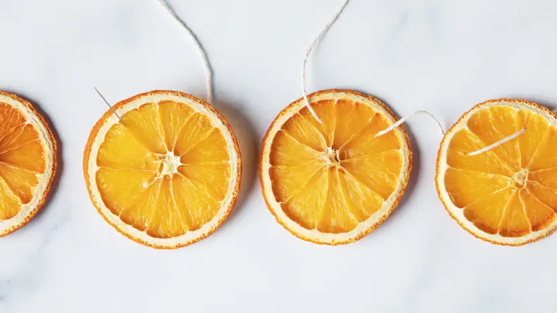 Dried oranges with a needle and twine strung through.
