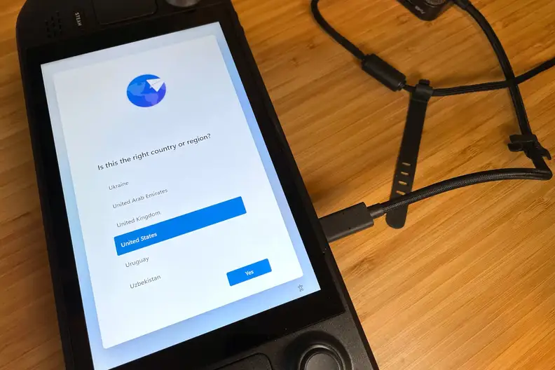 A black handheld gaming console showing part of the Windows 11 OS installation process