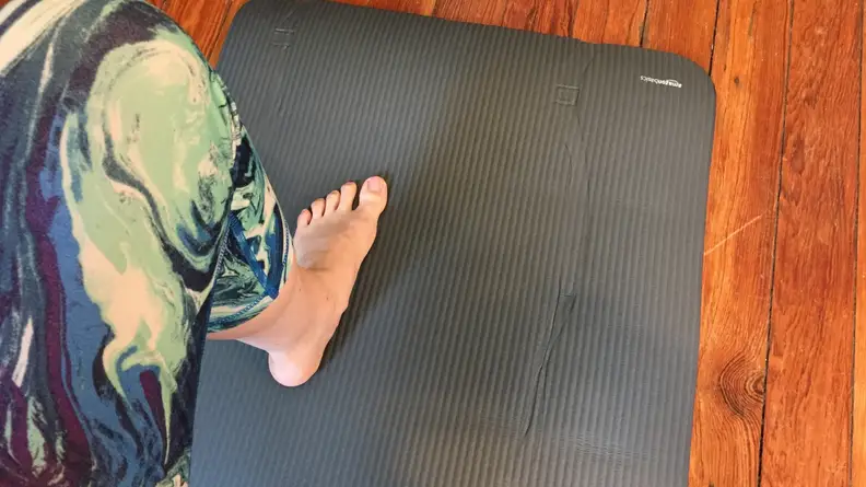 Someone stands on a yoga mat