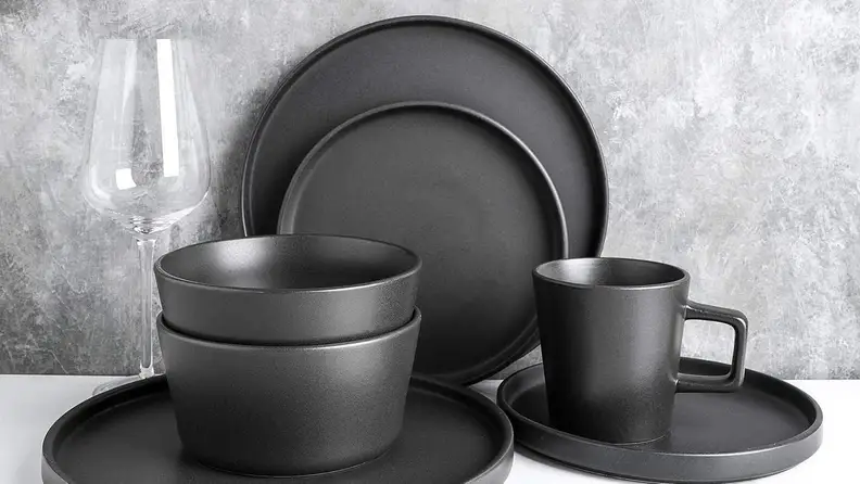 A stack of black dishware sets.