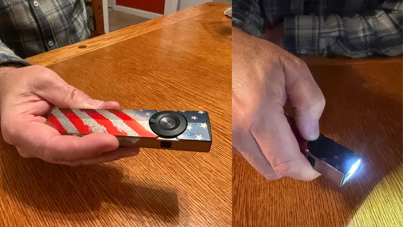 A man holds a flashlight with an American flag design