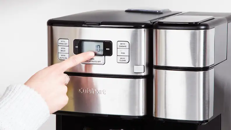 A person pressing buttons on the Cuisinart Grind and Brew Plus control panel.