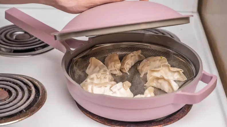 Pink pan with dumplings steaming inside.