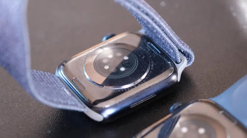 Close up of the smart sensor on the back of two Apple smartwatches with navy wristbands.