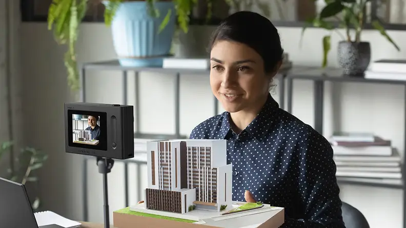 A person using the Acer SpatialLabs Eyes stereo camera to display an architectural model.