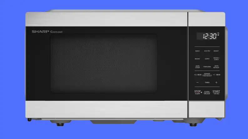A black microwave on a blue background