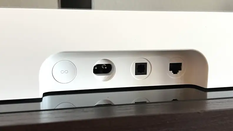 The input section for the white Ray soundbar is shown on a black and brown console.