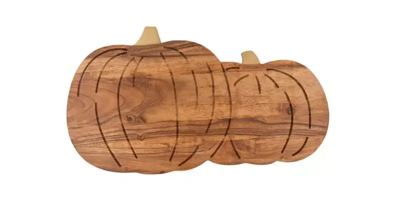 An image of a cutting board carved in the shape of two pumpkins next to one another.