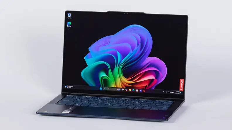 The Lenovo Yoga Slim 7x laptop sitting opened with colorful screensaver on the desktop.