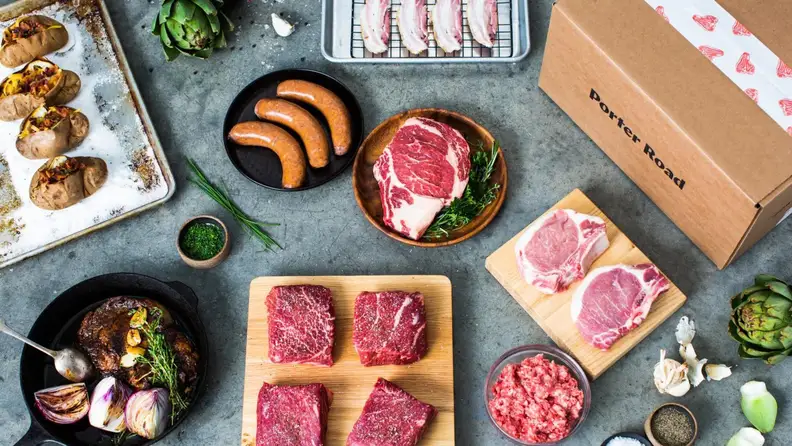Several raw cuts of meat and a Porter Road box laid out on a countertop