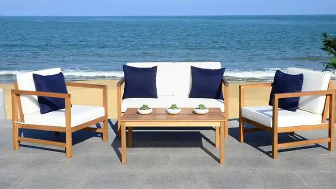 Light wooden furniture with white cushions overlooking the ocean