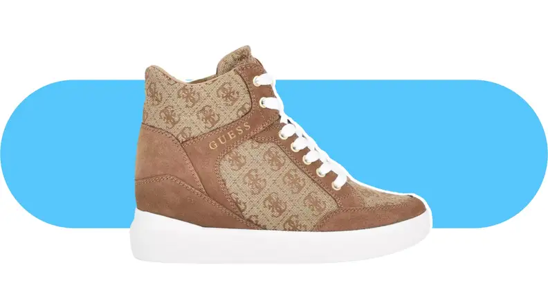 A tan wedge sneaker with the Guess logo on side panels.