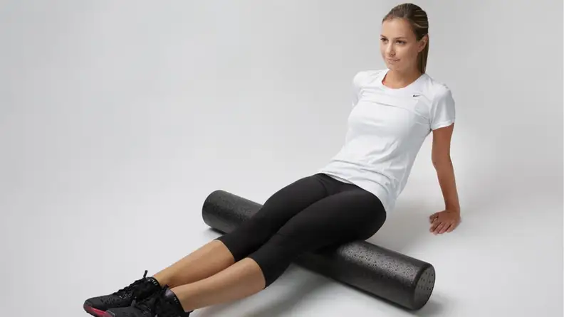 woman using a foam roller on her leg