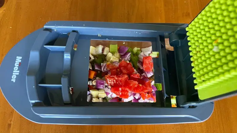 Assorted chopped vegetables within the clear container part of the Mueller Vegetable Chopper.