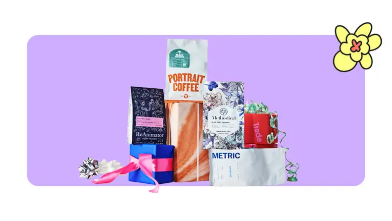Assorted bags of coffee from Trade Coffees in front of a purple background with a yellow cartoon flower in the corner.