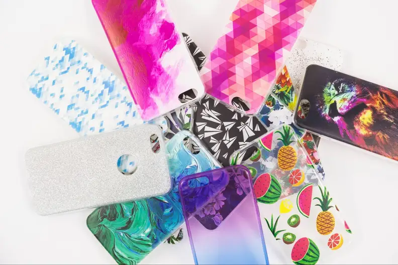A flat arrangement of colorful, patterned smartphone cases on a white background.