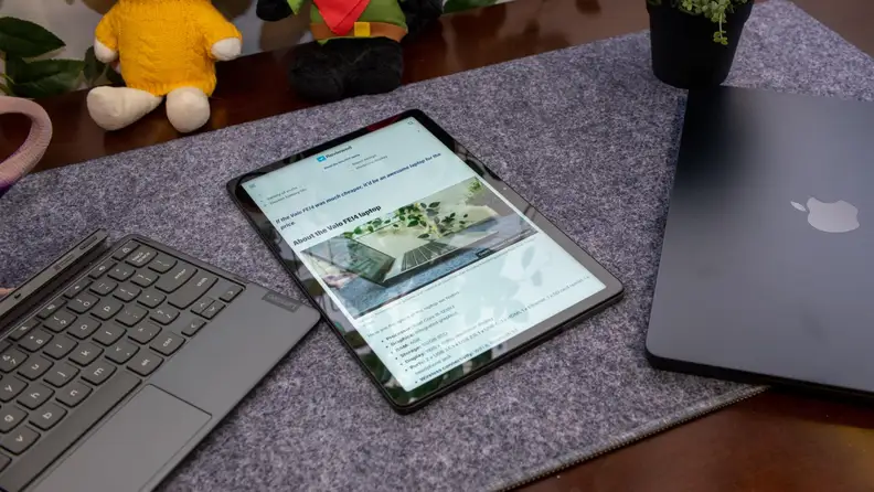 The Chromebook Duet 3 shown next to a macbook laptop and its keyboard.
