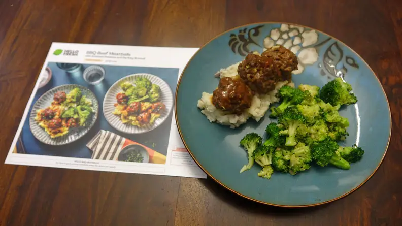 A plate BBQ Beef Meatballs with Smashed Potatoes beside a recipe card.