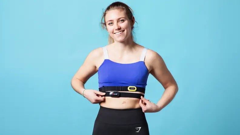 A person blue wearing athletic attire with both the Garmin HRM-Pro and Polar H10 heart rate monitors around their chest.